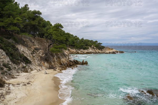 Mega Portokali Beach in southern Greece features a secluded sandy cove with turquoise waters and