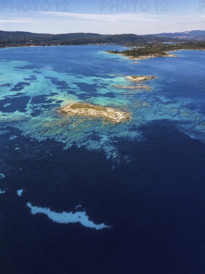Aerial view of Diaporos Island with vibrant turquoise waters and rocky formations, surrounded by