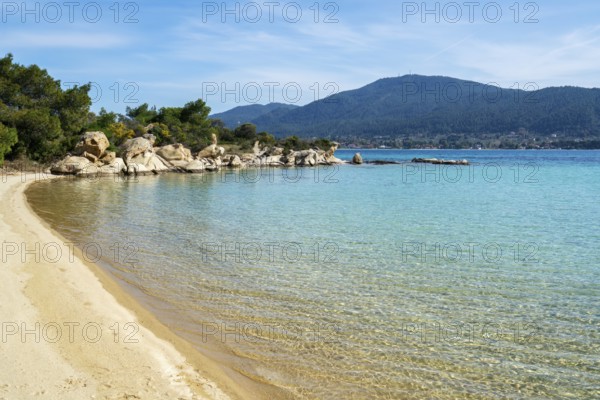 A pristine beach on Diaporos Island in Greece with turquoise waters and golden sand. Surrounded by