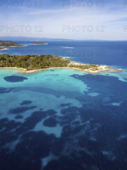 Aerial view of Diaporos Island and Karydi Beach, Greece, with bright turquoise waters, green