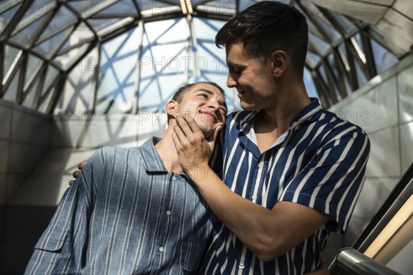 A loving gay couple shares a warm embrace on the streets of Madrid. Capturing genuine affection and