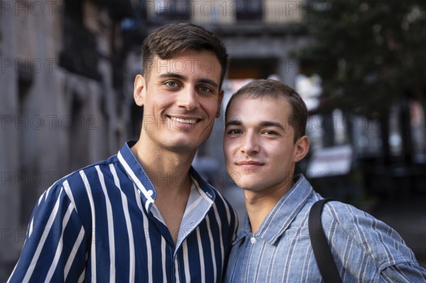 A smiling gay couple enjoys a sunny day while strolling through the lively streets of Madrid. The