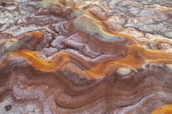 Capture of Utah's bentonite formations, showcasing swirling patterns and vibrant hues of gold and