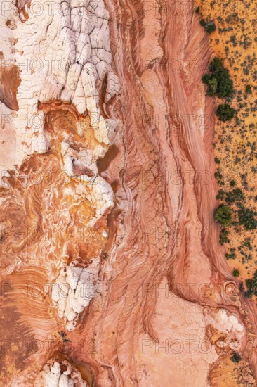 Stunning top-down view of intricate red and white rock patterns in a desert landscape, showcasing