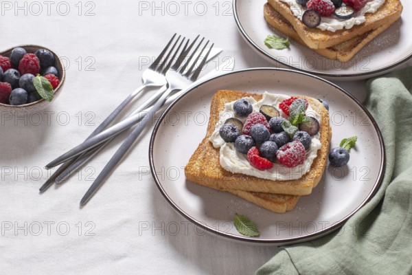 Delicious serving of toast laden with cream cheese and topped with fresh raspberries and