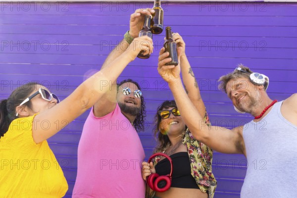 A joyful group of LGBTQIA+ friends toasting with drinks in celebration. Diverse individuals express