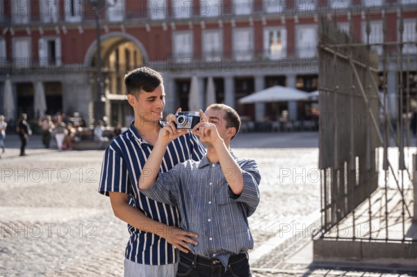 A joyful gay couple enjoys a sunny day in the bustling streets of Madrid. Capturing memories with a