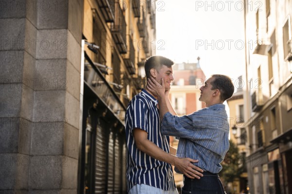 A gay couple shares a tender moment in the vibrant streets of Madrid. The warm light and intimate