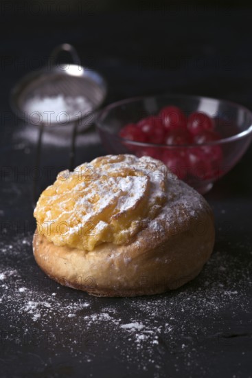 A freshly baked cream bun generously topped with a layer of velvety cream and dusted with icing
