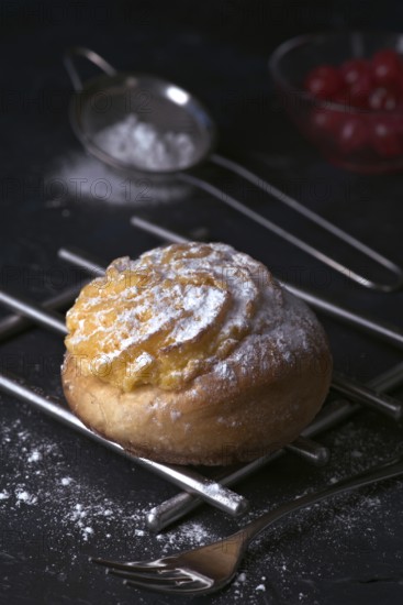 A delectable freshly baked cream bun, generously filled with smooth cream and dusted with fine