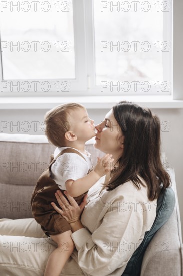 A heartwarming scene of a son kissing their mother on the nose, capturing love and affection in a
