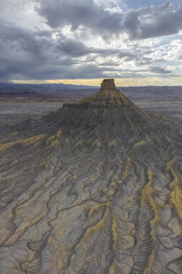 Aerial view of a rugged desert landscape, with intricate textures and eroded landforms under a