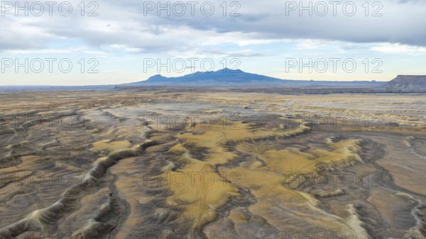 Aerial view of vast desert plains in USA with undulating terrain and patches of sand dunes, framed