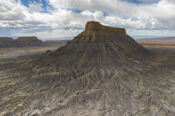 A striking aerial view of a weathered plateau with deep ridges and a barren landscape, under a