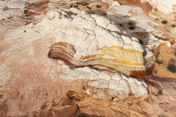 Aerial view of sandstone formations showcasing layered textures and vibrant colors in White Pocket.