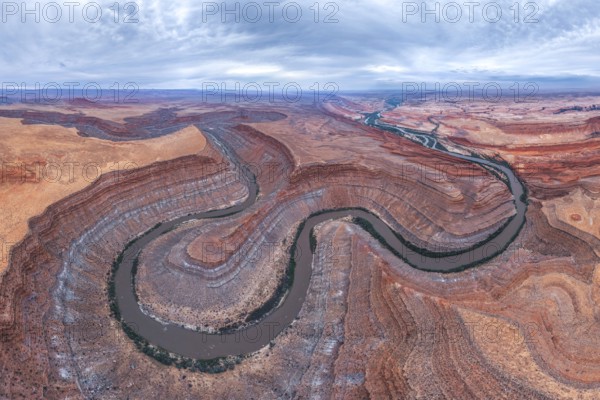 Captivating aerial view of a river winding through the dramatic, layered San Juan canyon. The