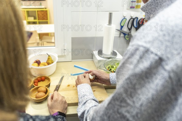 A couple with intellectual disabilities is preparing a healthy meal in a modern kitchen of a