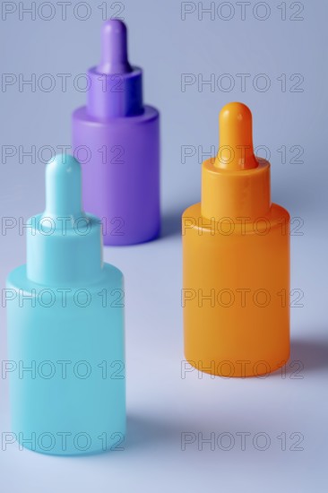 A trio of vividly colored serum bottles in purple, orange, and teal, arranged aesthetically against