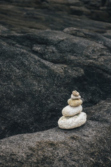A stack of balanced stones on a rocky surface in a peaceful outdoor environment. Concept of