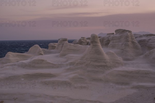 Serene evening view of the distinctive white rock formations at Sarakiniko Beach on the island of