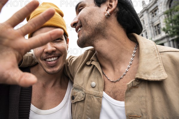 A happy gay couple enjoys a day out, displaying affection and a carefree attitude. The focus is on