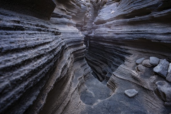 Intricate volcanic rock formations showcasing layered textures inside the popular natural cave in