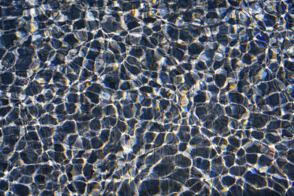 Sunlight dances on the rippling waters of Playa Blanca Port, Lanzarote, creating a mesmerizing