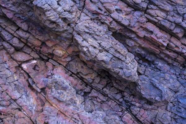 Close-up image displaying the intricate textures and varying colors of volcanic rocks at Mujeres
