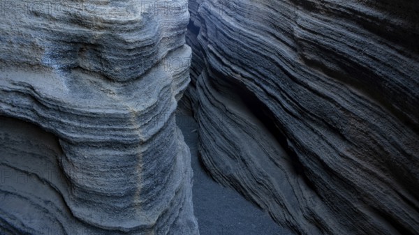 Enigmatic, winding rock formations in Lanzarote, showcasing textured geological layers in shades of