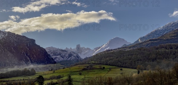 Stunning panoramic view of the mountains, showing snow-capped peaks and lush green valleys under a
