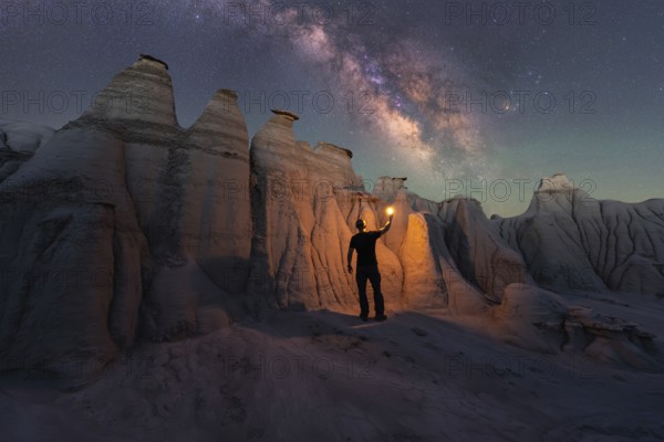 A lone figure illuminates the magnificent sandstone formations of Goblin Valley State Park, Utah,