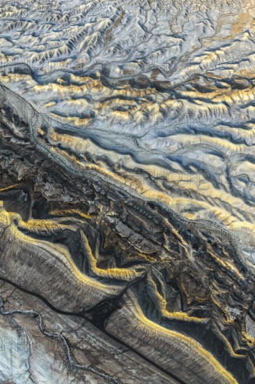 Aerial photograph showcasing the intricate golden sandstone formations of the Utah desert. The
