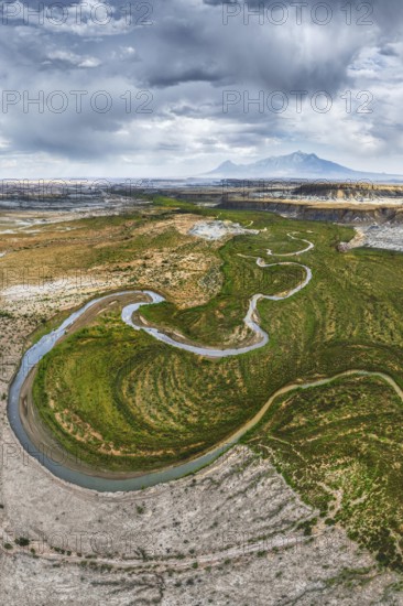 A breathtaking aerial drone photograph captures a winding river snaking through the rugged terrain