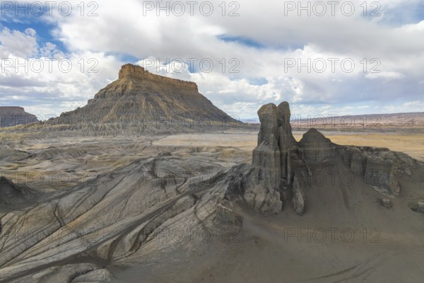 A breathtaking landscape featuring a towering desert mesa and striking rock formations under a