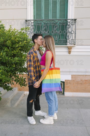 A happy lesbian couple shares a tender moment outdoors, celebrating their love and pride. One