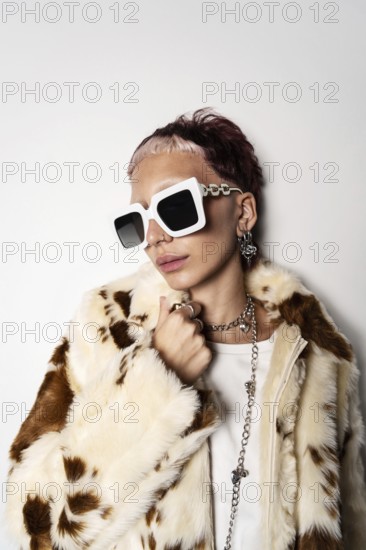 Fashion-forward woman wearing a faux fur coat and oversized white sunglasses, showcasing trendy