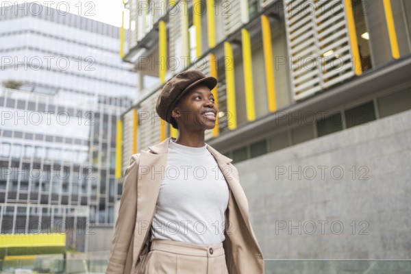 A fashionable black woman walks through an urban area, surrounded by contemporary architecture Her