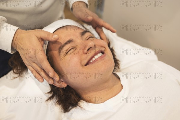 A man enjoys a relaxing facial massage using organic products The atmosphere is serene, promoting