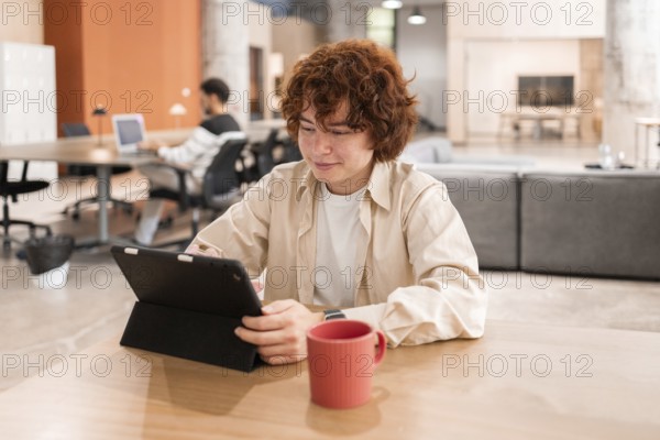 Young professionals working on laptops in a modern, open-plan office The focus is on collaboration,