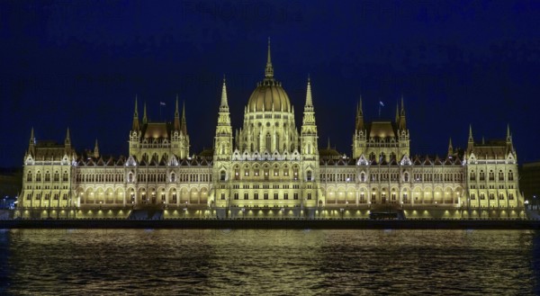 The Hungarian Parliament Building, illuminated at night, reflects its grandeur on the waters of the