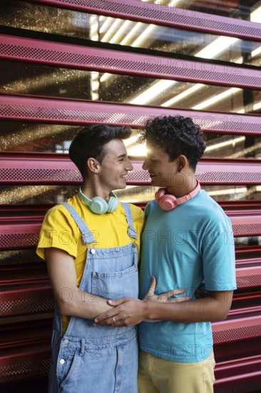 A joyful couple, wearing colorful casual outfits, share a loving moment. They look at each other