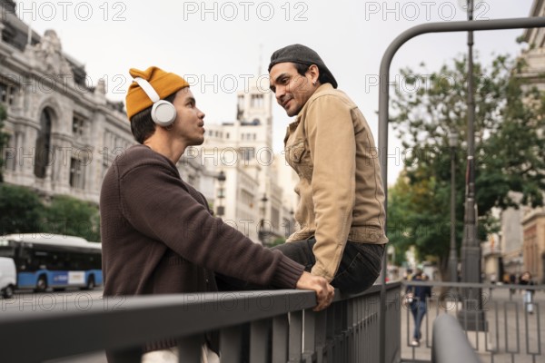 A Colombian couple enjoys a moment together in Madrid city, one listening to music with headphones,
