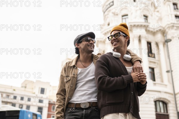 A joyful colombian gay couple enjoying a casual city walk. Both are wearing sunglasses and