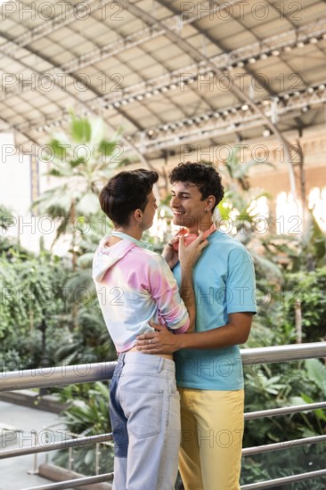 A cheerful gay couple embracing in a lush indoor garden. Their colorful outfits and vibrant