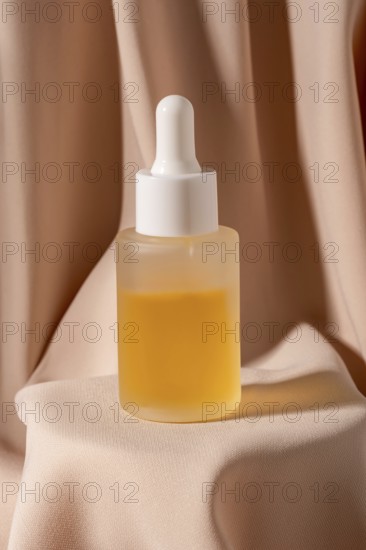A minimalist flat lay photo featuring a glass dropper bottle of golden skincare The bottle is