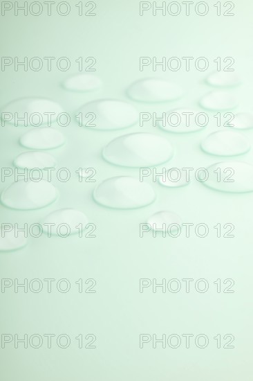 Droplets scattered on a smooth mint green surface, creating a calming and refreshing scene Soft