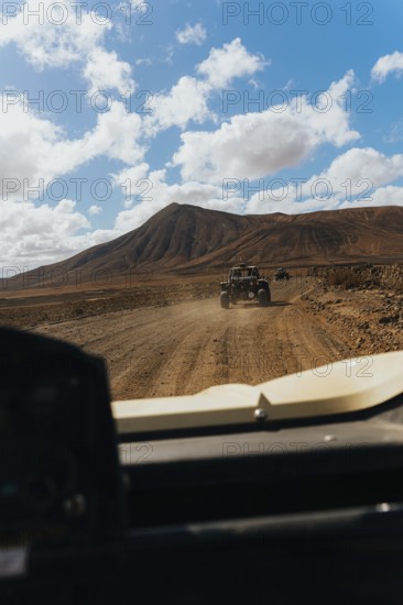 Lanzarote's rugged terrain from a buggy. Vast volcanic landscapes, scattered clouds and a scenic
