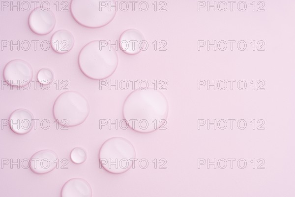This image displays a pastel pink background with clear droplets, creating a serene and calming