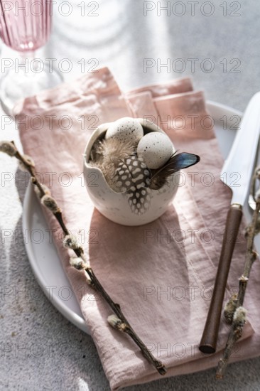From above, an artistic Easter table arrangement features a porcelain bowl with speckled eggs,