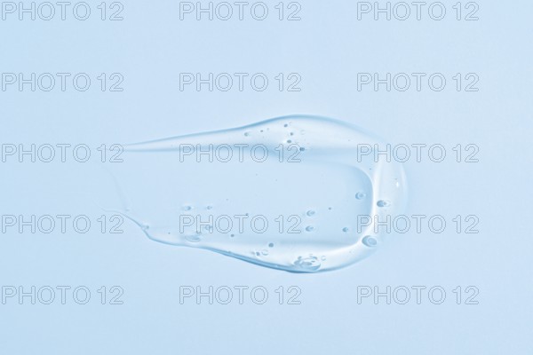 A translucent blue gel-like substance with a smooth, creamy texture, smeared in an elegant, fluid